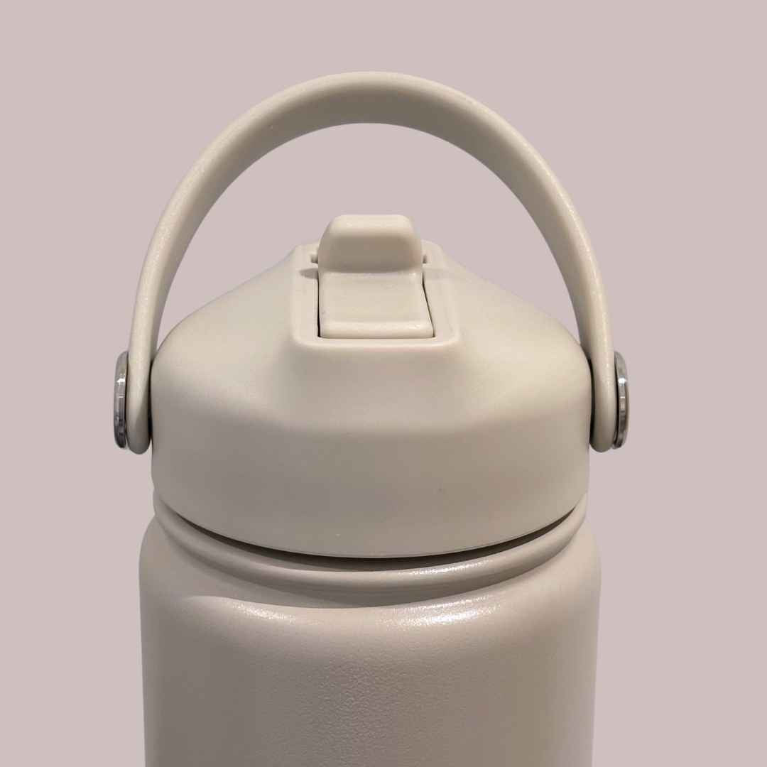 Kids water bottle easy-sip straw lid with handle front view on taupe beige Grip bottle 